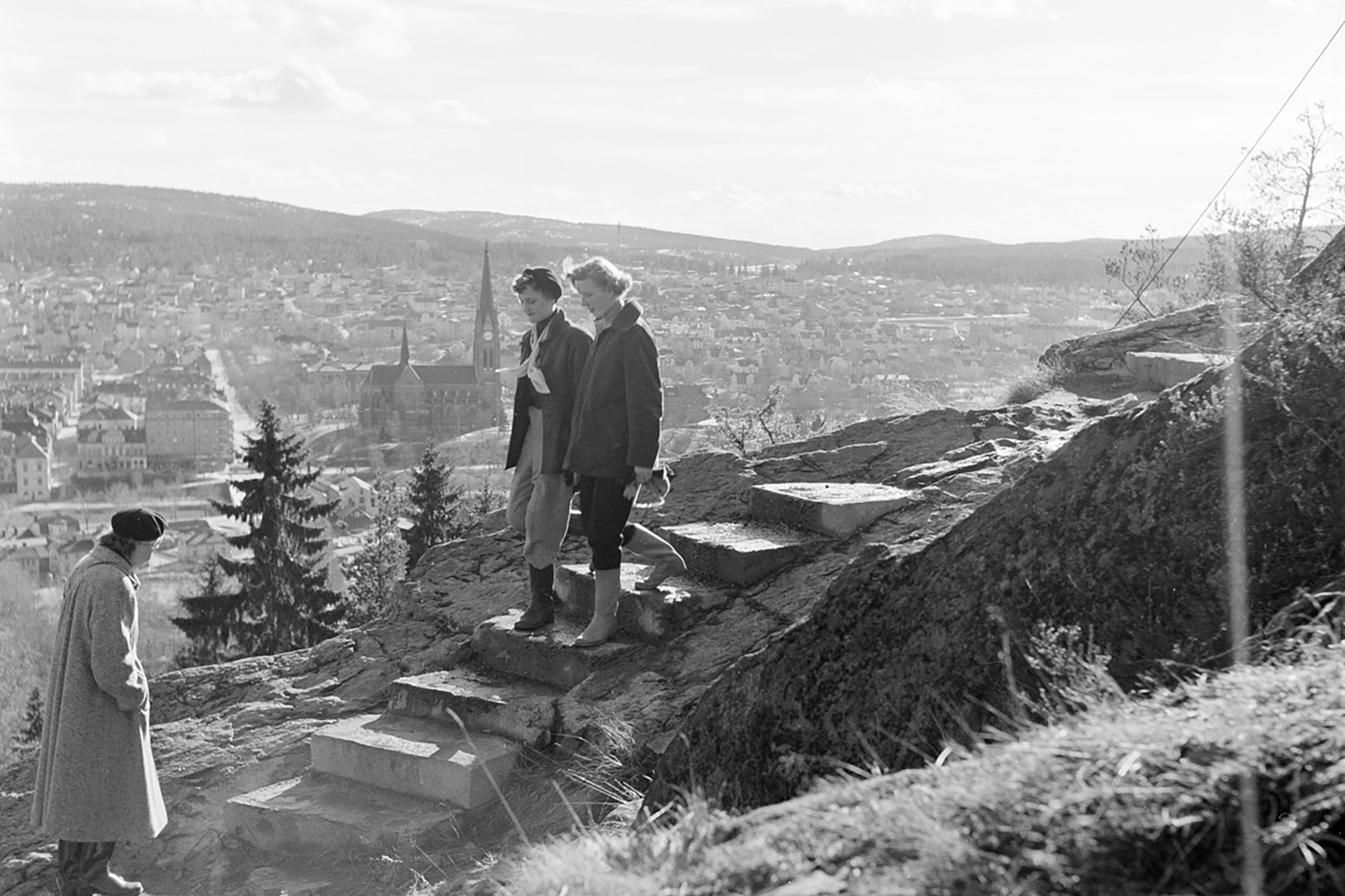 Tre kvinnor går i trappan som går upp till berget. Foto: Sundsvalls museums fotoarkiv.