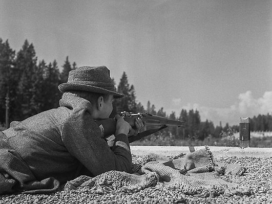 Man ligger och siktar på skjutvall. Foto: Sundsvalls museums fotoarkiv.