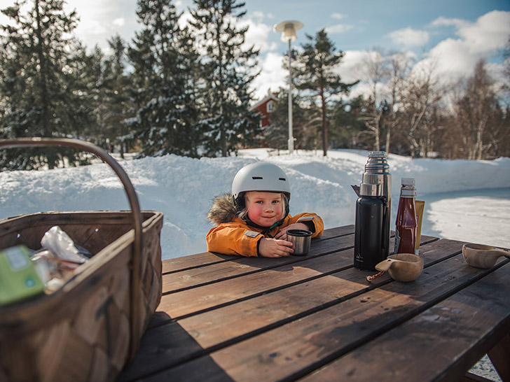 Barn som fikar vid isbanan. Foto: Norra Berget.