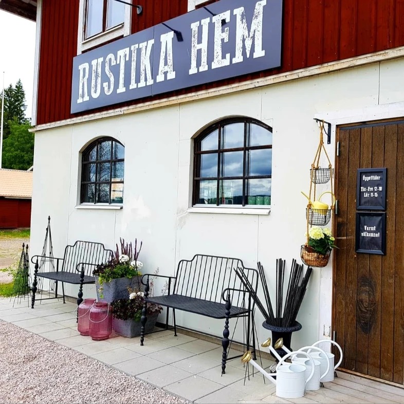 Två bänkar som står mot husfasad till butiken Rustika hem