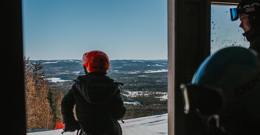 En pojke i slalomutrustning som blickar ut över fin utsikt