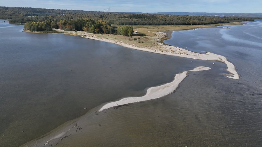Drönarfoto över en långsmal udde omringad av havet.
