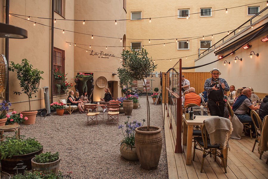 Bild av en innegård med restaurangbord.