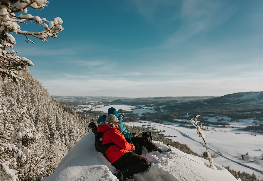 Två personer som tittar på utsikten från ett berg
