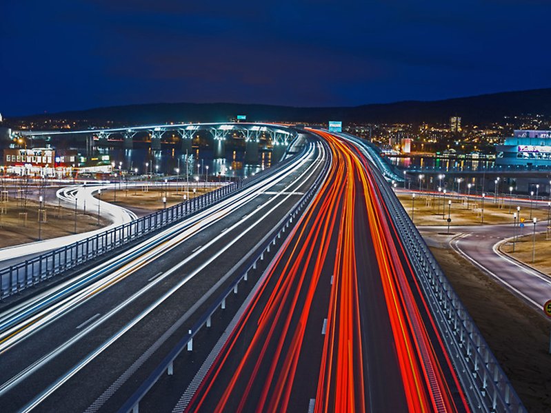 Fotografi av Sundsvallsbron på kvällen. Fotot är taget ovanifrån.
