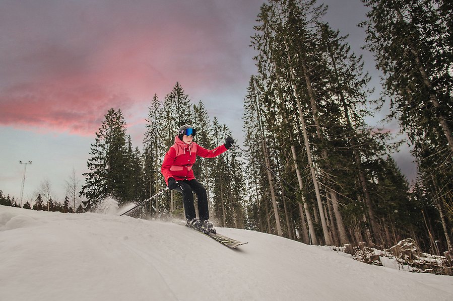 Fotografi av en kvinna som åker slalom nedför en slalombacke.