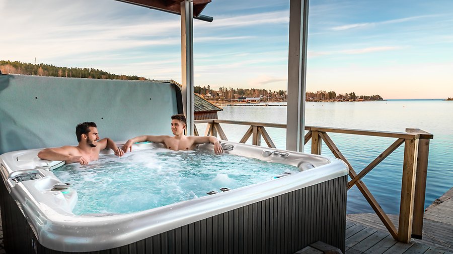 Foto av två personer som sitter i en bubbelpool på en brygga.