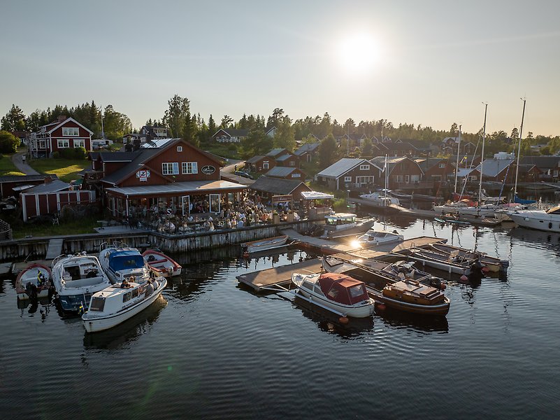 Två kvinnor står framför en eldstad och pratar.